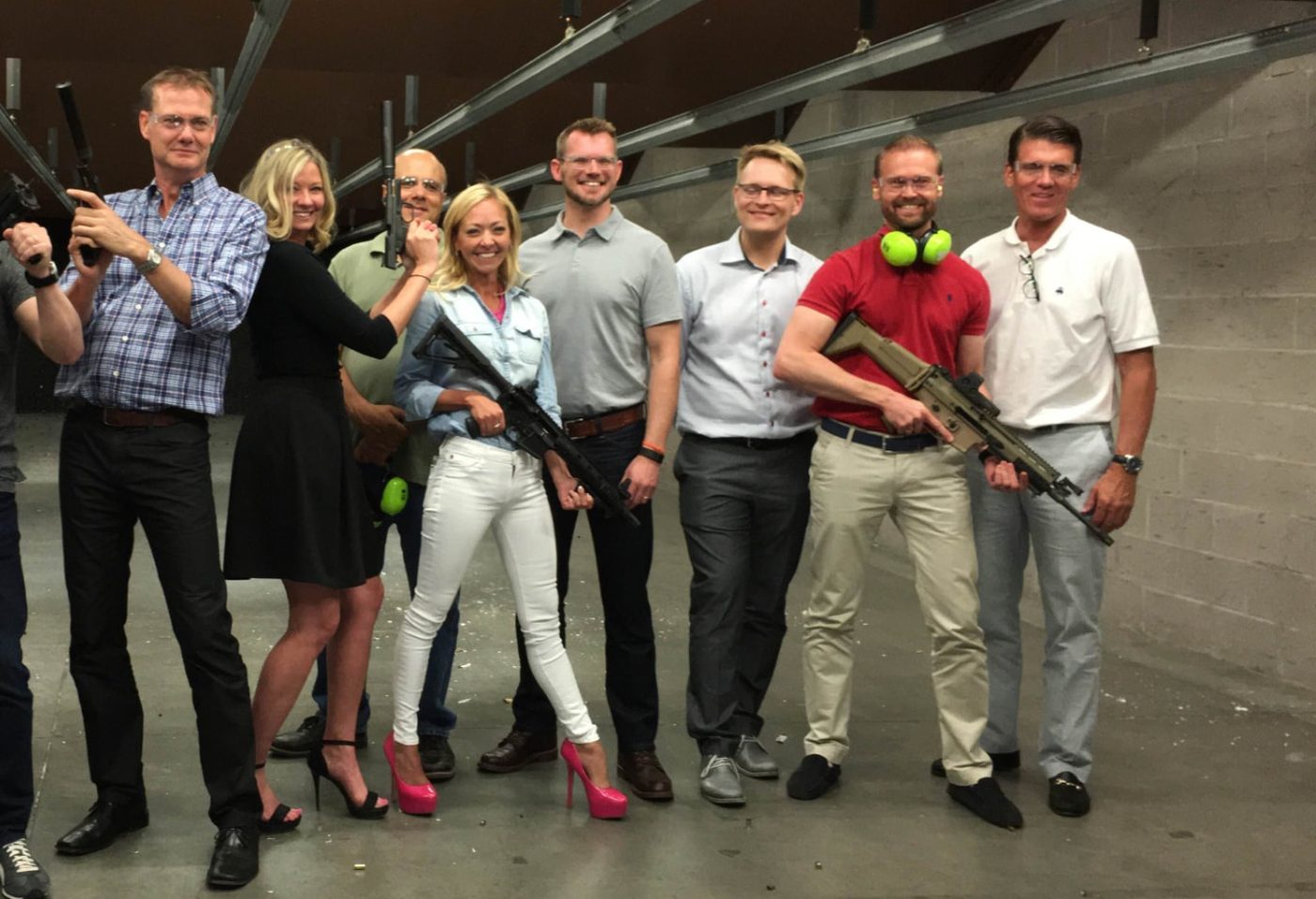 Corporate team in business casual attire at a modern indoor shooting range